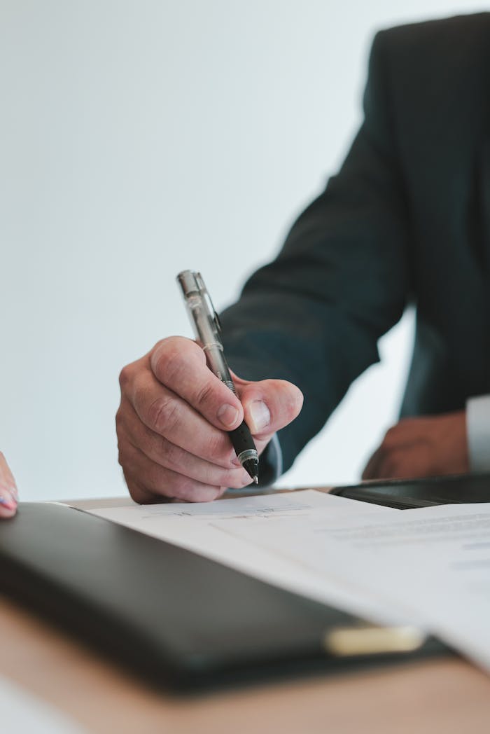 Services A businessman in a suit signing a contract in an office setting, emphasizing professional context.